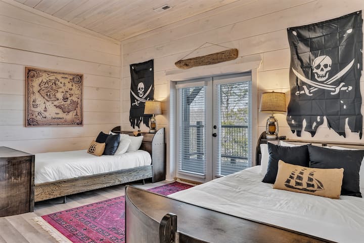 Pirate Room with two queen beds, TV, and ensuite bath.