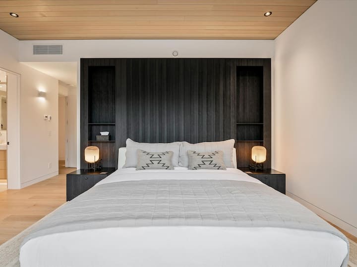 חדר שינה ראשי בקומה העליונה עם מיטת קינג סייז וחדר רחצה צמוד