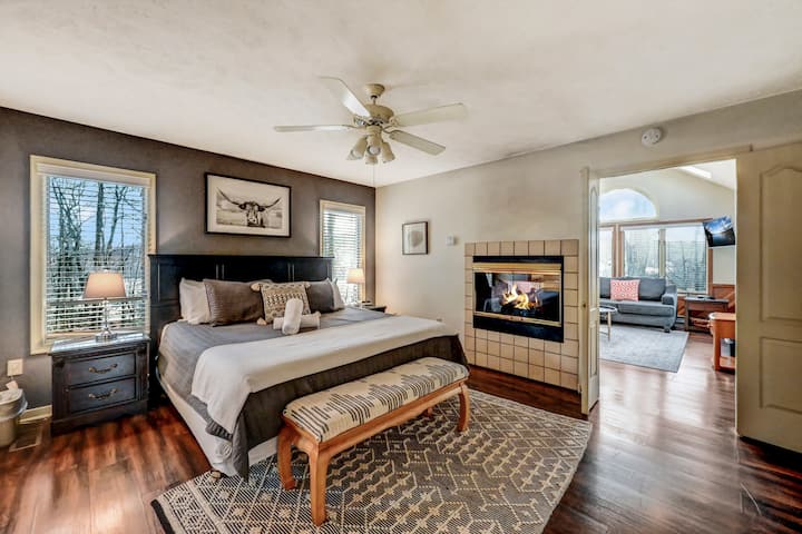 Dormitorio en el piso principal con cama tamaño king, chimenea y baño privado