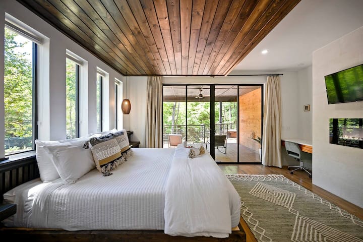 Горна спалня с голямо двойно легло — светла и просторна с много прозорци, плюшено голямо двойно легло и телевизор с плосък екран за уютни нощи.