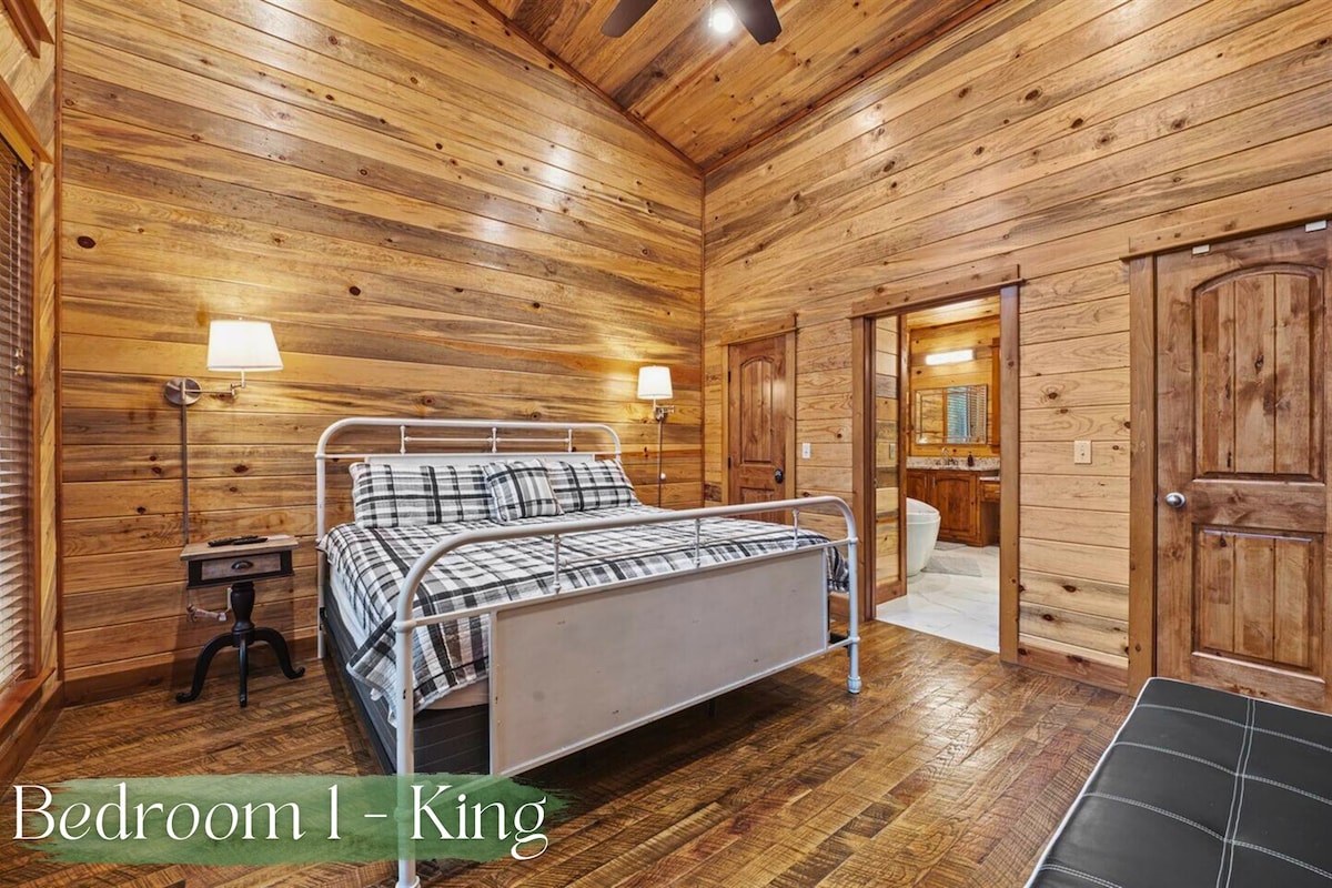 استمتع بالراحة في غرفة النوم هذه التي تضم سرير كينج والتي تتميز بجدران خشبية ريفية ولمسات مريحة، وهي مثالية لقضاء ليلة مريحة.