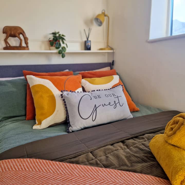 A cosy, well-styled bedroom with soft lighting and plush pillows, designed to offer a warm and inviting space to unwind. Perfect for longer stays where comfort and good rest truly matter.