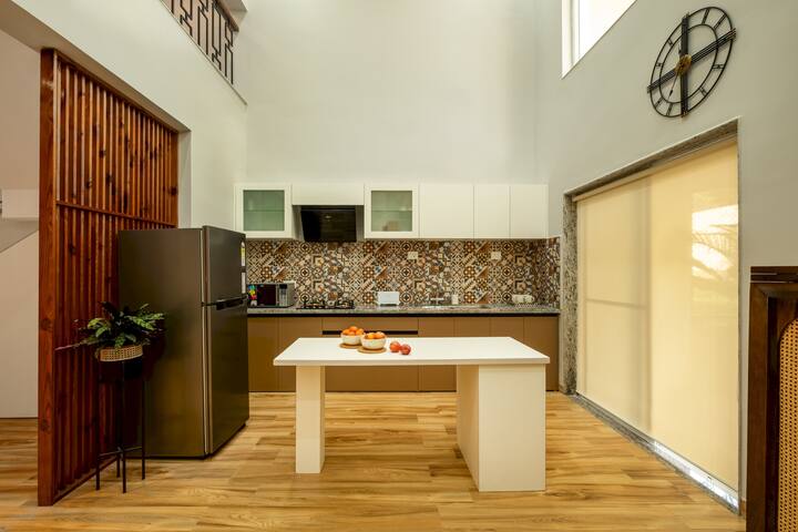 The villa features a fully equipped modern kitchen with top-of-the-line appliances, including a refrigerator, stove, oven, and microwave.