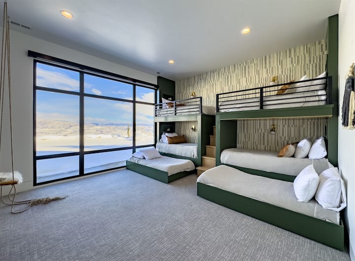 Groene stapelkamer met vier eenpersoonsbedden, twee eenpersoonsbedden, hangende schommel en 75inch tv. 