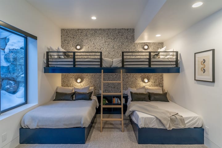 Blauwe stapelbedkamer met twee tweepersoonsbedden, twee tweelingen, rotsklimfunctie en 75inch tv. 