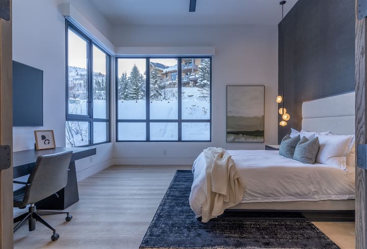 Slaapkamer op de bovenste verdieping met queensize bed en kantoorruimte. 