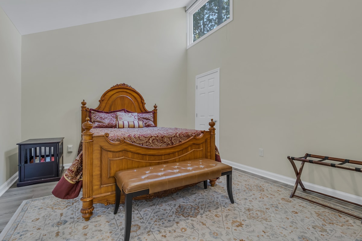 Chambre avec lit queen size avec caisse pour chien de petite ou moyenne taille.