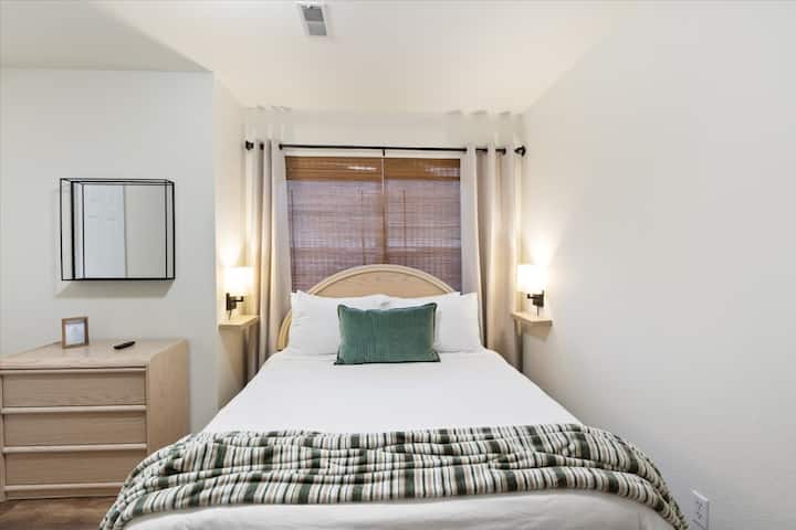 Un lit queen size est placé au centre de cette chambre d'amis, ce qui permet d'avoir une vue dégagée sur l'espace de couchage.