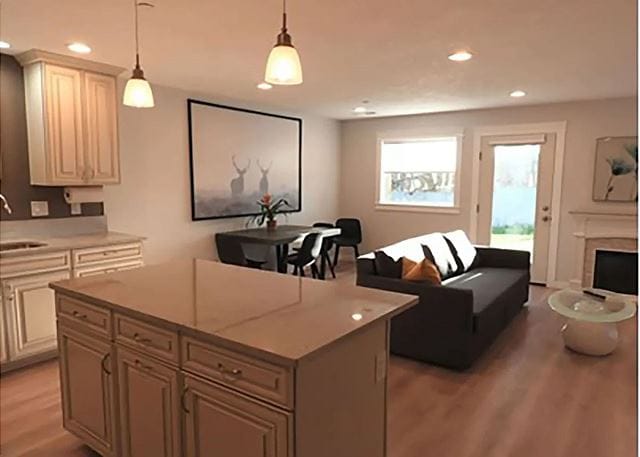 An open-concept living area is highlighted by a modern sofa facing a glass coffee table. The kitchen features light cabinetry and a central island. A dining table is set for four, and large windows allow natural light to fill the space.
