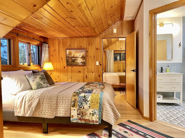 חדר שינה ראשי עם נוף לאגם, מיטת קווין סייז ומיטות נפרדות.