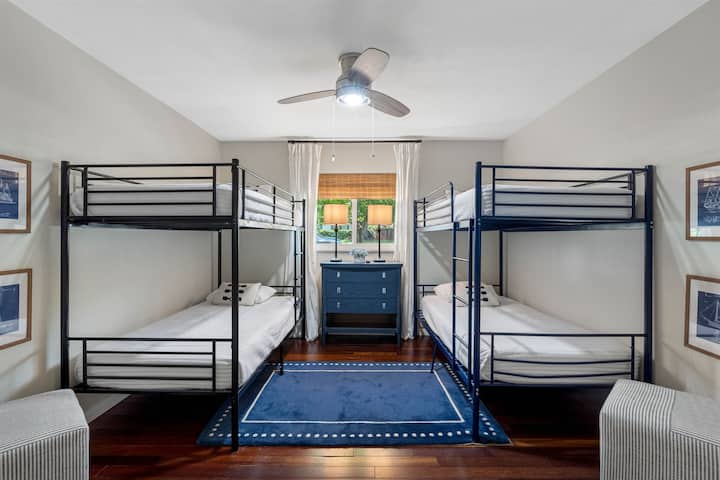 A fun and functional bunk room featuring two sets of twin-over-twin bunk beds, perfect for kids or group stays.
