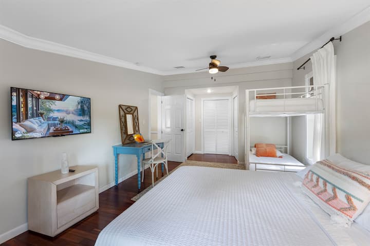 A versatile guest bedroom featuring a queen bed and a bunk bed, ideal for families or group stays.