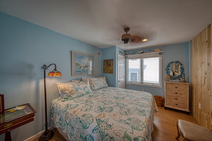 Č. 5 Spálňa s priestrannou manželskou posteľou, výhľadom na oceán, lampičkou na čítanie, stropným ventilátorom, stolom na hru Monopoly a kreslom.  V skrini je posteľná bielizeň pre 2 rozkladacie pohovky na 2. poschodí apartmánu LVR.  Je tu miesto pre detskú postieľku s ohrádkou.