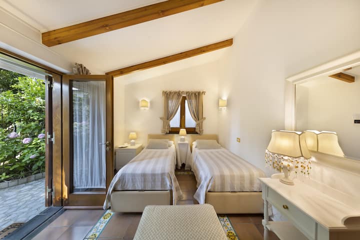 Dormitorio 1 - Dormitorio con dos camas individuales, TV de pantalla plana y acceso al jardín