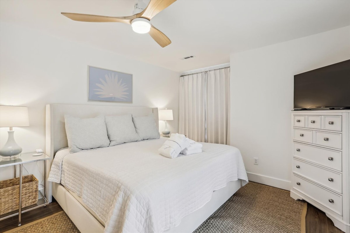 Hoofdslaapkamer, 1e verdieping: comfortabel kingsize bed, smart-tv, eigen ingang naar de patio, opbergruimte en een plafondventilator voor extra comfort en sfeer