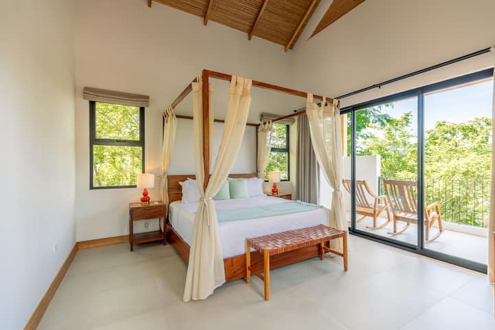 Disfruta de una comodidad incomparable en el dormitorio principal en. Este amplio refugio cuenta con una decoración sofisticada, una cama suntuosa y acceso directo al aire libre, lo que garantiza una estancia relajante y lujosa en medio de un entorno sereno.