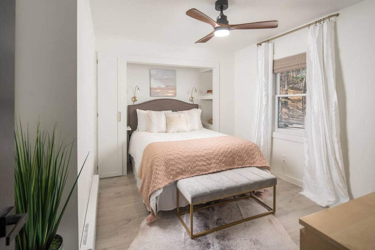 Брачна спална соба опремена со душек од висока класа, висококвалитетни линии за дишење, приклучоци за електроника, завеси за затемнување и 50-инчен паметен телевизор со многу популарни апликации за стриминг.