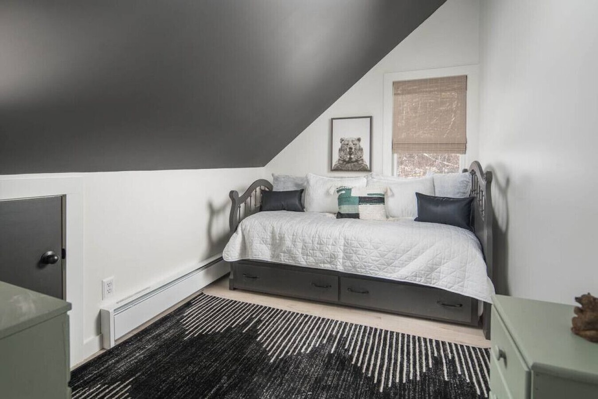 Детска соба со два душека, алтернативни шалтери во близина на детското поткровје за игри.