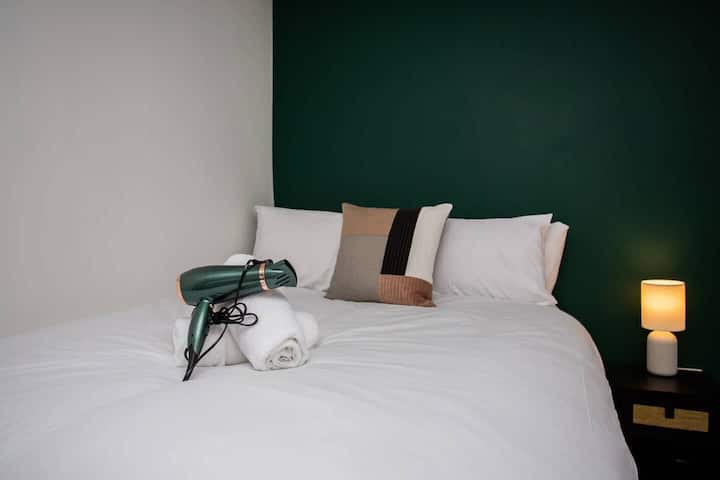 Priamo na posteli stojí elegantný sušič vlasov, ktorý poskytuje extra nádych starostlivosti a pohodlia pre vaše potreby starostlivosti. 