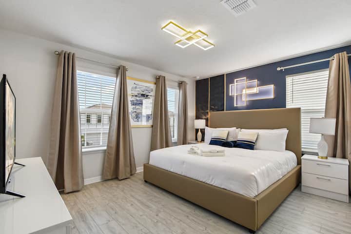 Quarto sofisticado com cama king, iluminação ambiente e toques marinhos elegantes