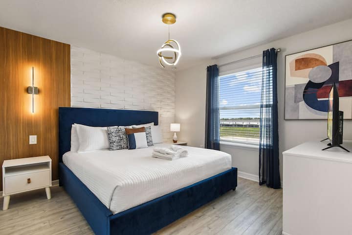 Quarto king moderno com parede texturizada, decoração arrojada e vista para a luz natural