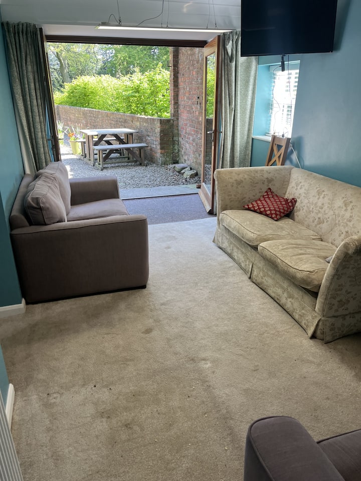 סלון ייעודי עם ספות, טלוויזיה חכמה, חלונות צרפתיים ופאטיו