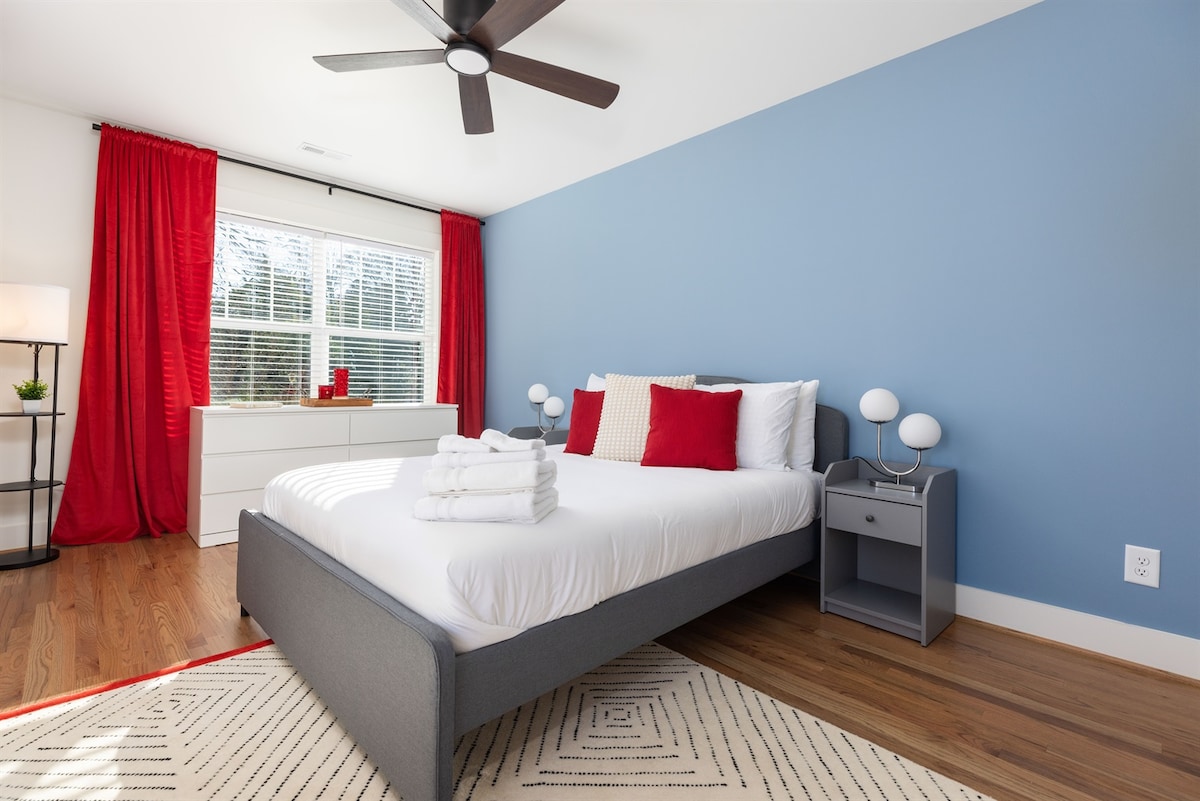 Chumba cha kulala cha malkia cha ghorofa ya juu kina mashuka ya kifahari, mapazia ya kuzima na feni ya dari ya juu kwa ajili ya mtiririko wa hewa kwa ajili ya usingizi bora wa usiku.