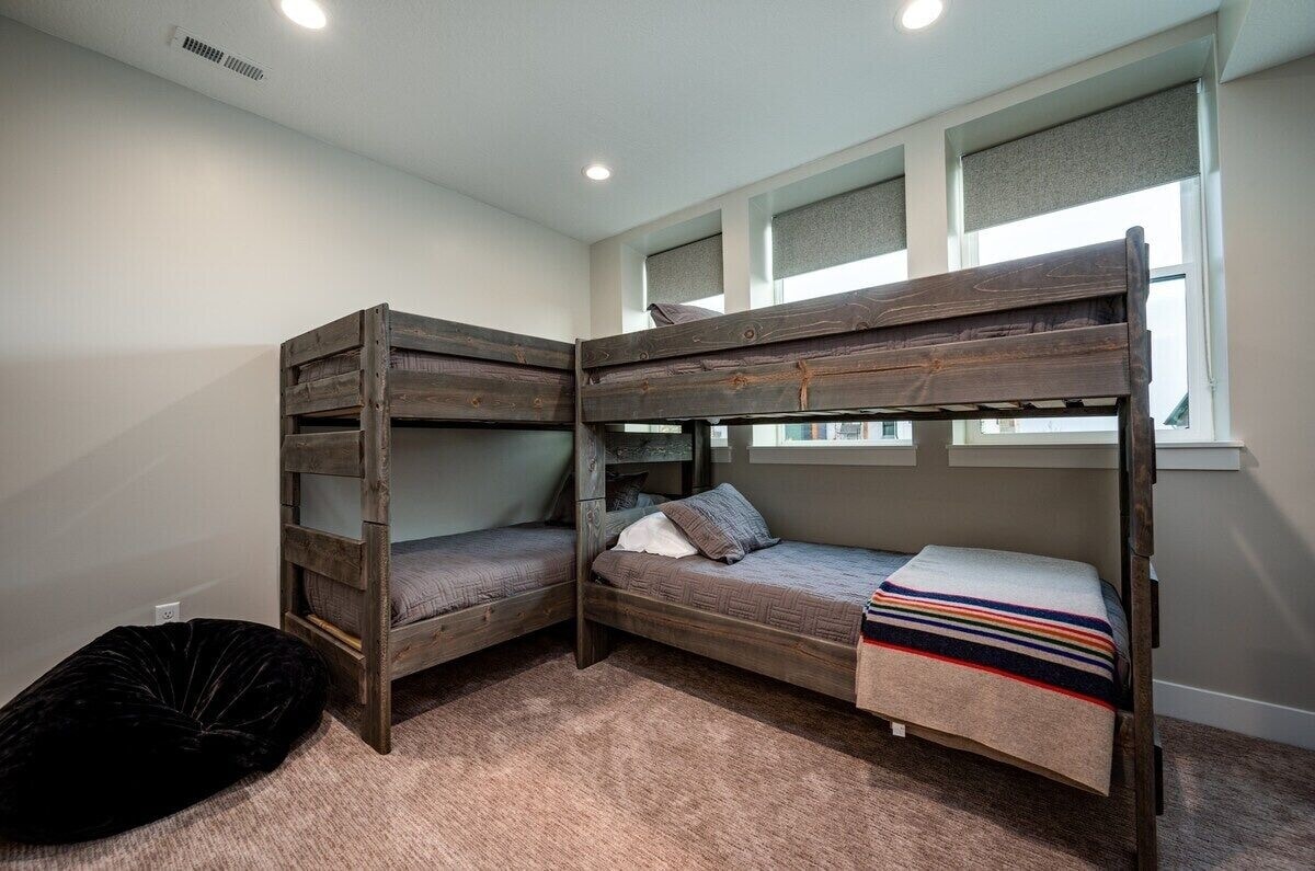 Vitanda vya ghorofa katika chumba cha kulala cha tatu huchukua wageni wanne, vyenye nafasi kubwa na mwanga wa asili.