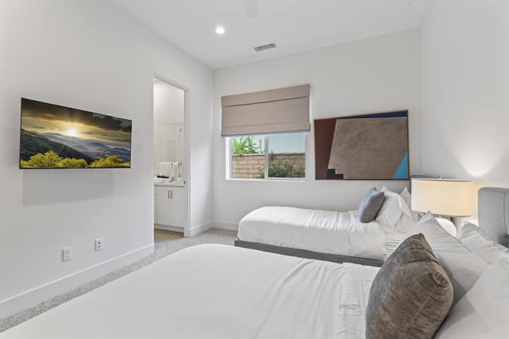 Tercer dormitorio con una cama tamaño queen, una cama individual XL y un televisor de 50".