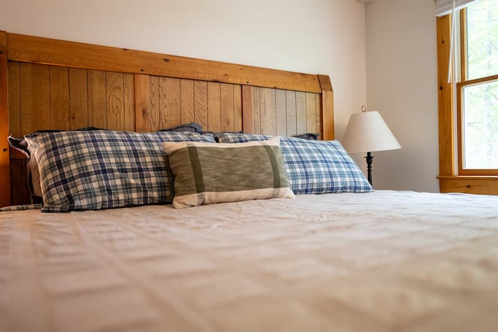 King bed with pillows and window on the right