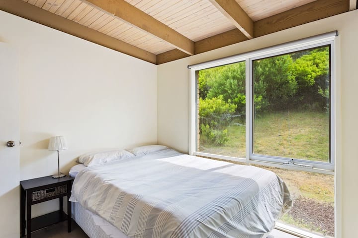 De vierde slaapkamer biedt een queensize bed, compleet met ontspannend, met bomen omzoomd uitzicht.
