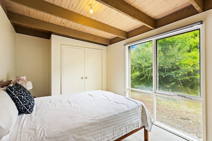 De derde slaapkamer heeft een queensize bed met uitzicht op de lommerrijke omgeving. 
