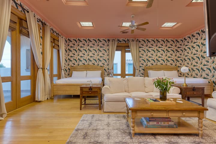 La chambre 5 de l'Hacienda dispose de deux lits king size en Californie, d'une télévision et d'un coin salon.