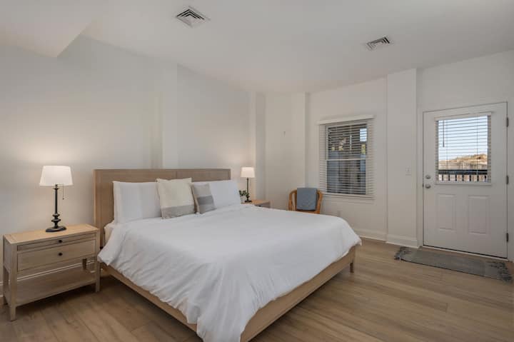 غرفة نوم بسرير كبير في الطابق السفلي مع حمام كامل