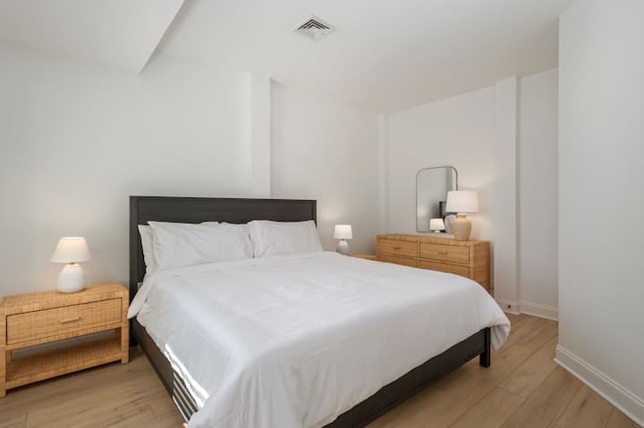 غرفة نوم بسرير كبير في الطابق السفلي مع حمام كامل