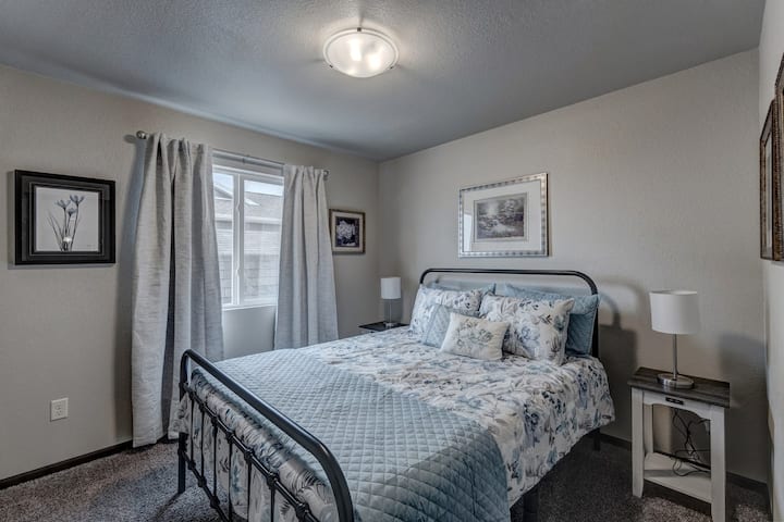 קומת קרקע חדר שינה שני עם מיטת קווין סייז ושידות לילה עם מטעני USB מובנים.