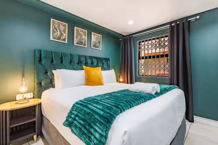 Elegantna i umirujuća spavaća soba bogatih zelenih tonova, s mekanim uzglavljem i ambijentalnom rasvjetom – osmišljena za mirne noći i boravke u stilu.