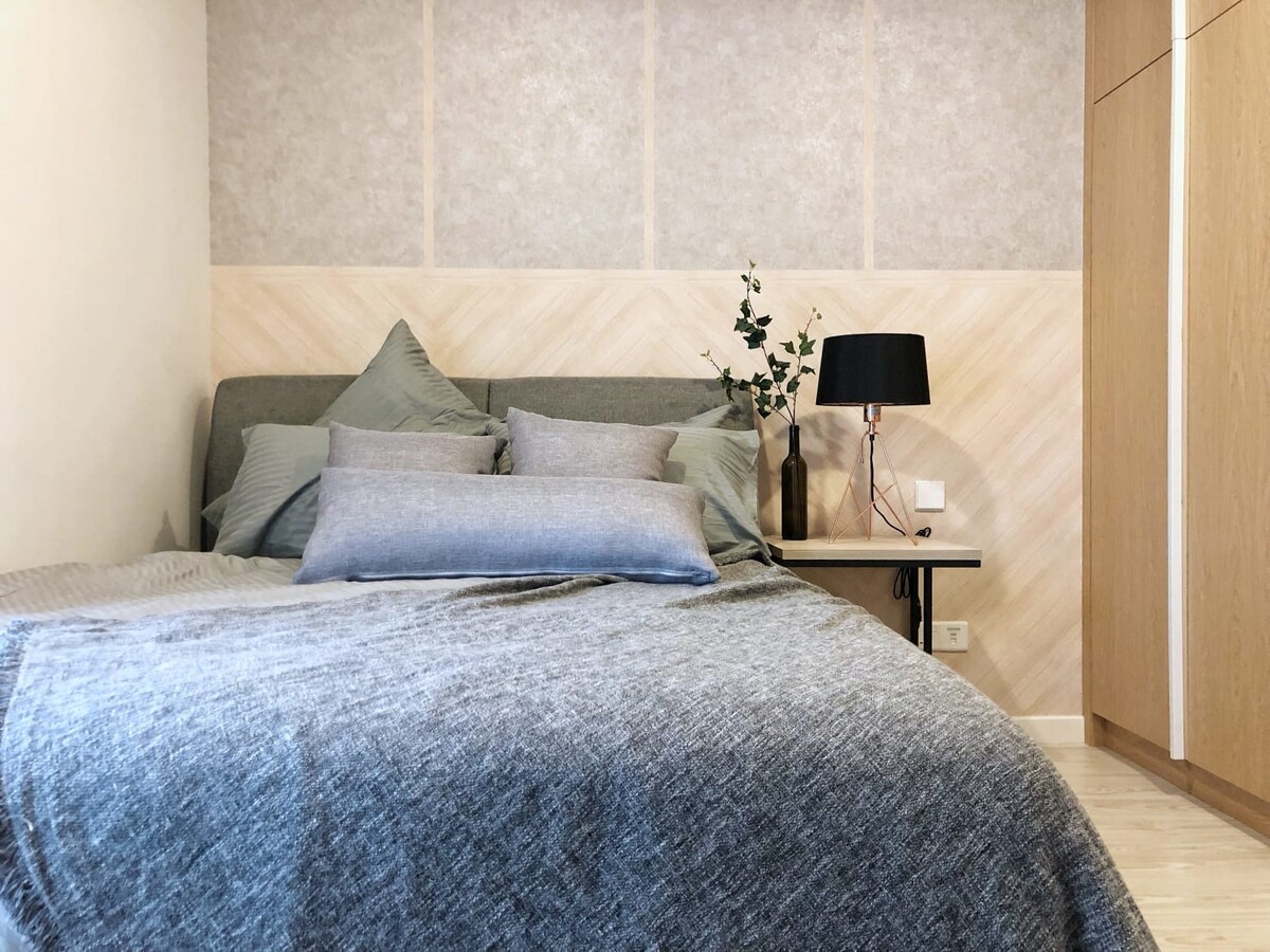 Მე-2 საძინებელი 152 × 203 სმ ზომის საწოლითა და პლუშის ბალიშებით.