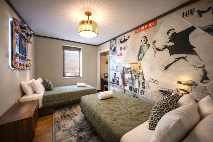 Creative Mural Bedroom with Two Comfortable Beds • Unique Urban Artwork, Modern Design and Flexible Sleeping Arrangements • Perfect for Friends, Families, Retreat Attendees and Group Travelers • A Memorable Space That Combines Comfort, Character and