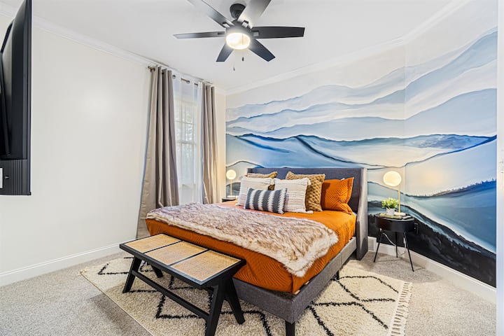 Camera da letto principale al piano principale con murale dipinto a mano raffigurante le Blue Ridge Mountains, Smart TV da 55" e accesso al bagno in comune con due porte comunicanti.
