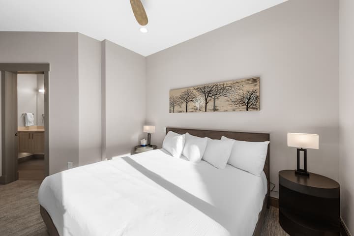 Dhomë gjumi për vizitorët e dytë me krevat dopio "king" dhe banjë brenda në suitë.