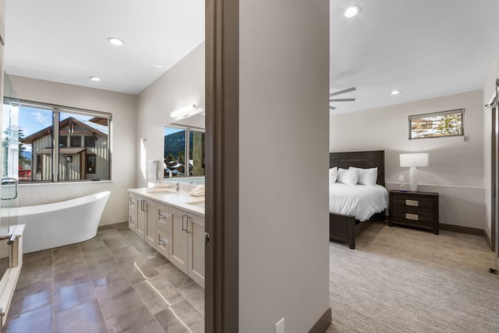 Dhomë gjumi kryesore me krevat dopio "king", televizor me ekran të sheshtë dhe banjë brenda në suitë me vaskë.