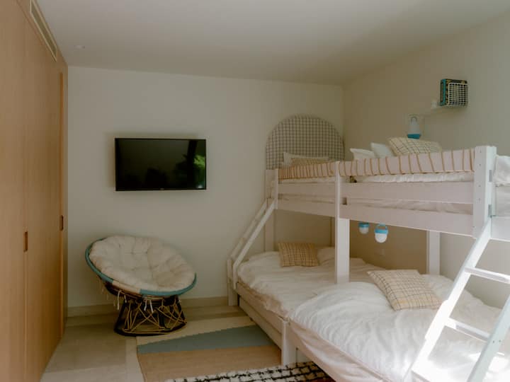 Una habitación luminosa diseñada pensando en las familias, el dormitorio de los niños cuenta con dos amplias literas, un sofá, juguetes y un televisor, ideal para que los niños se relajen y jueguen. 

