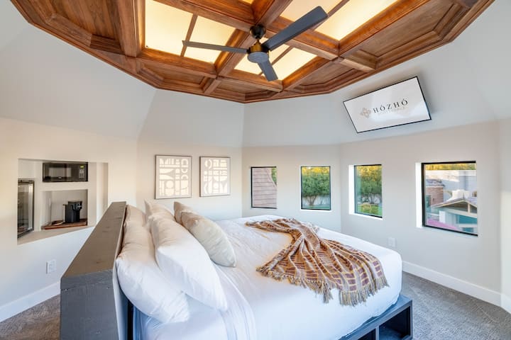 King Bedroom 10 w/Bafu Maalumu: Chumba cha kulala cha kipekee cha mtindo wa turret kilicho na dari ya kupendeza ya mbao, madirisha yanayozunguka, mandhari ya bwawa na vistawishi vya starehe vya ndani ya chumba.