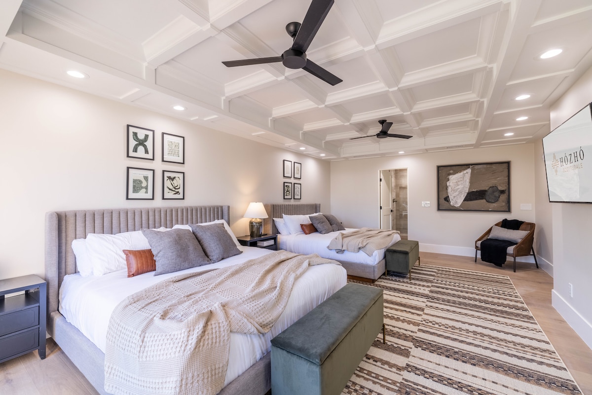 2 camas tamaño king con baño privado: amplia habitación con camas tamaño king dobles, detalles de diseño y asientos acogedores para grupos o familias.