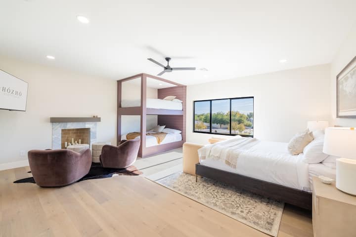 King Bedroom 6 w/Ensuite: Chumba cha kulala cha familia chenye nafasi kubwa kilicho na meko, kitanda aina ya king, na vitanda mahususi vya ghorofa ya kifalme kwa ajili ya wageni wa ziada.