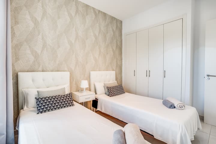 - חדר שינה זוגי מעוצב עם גוונים ניטרליים רכים ואוזניות נוחות - עיצוב מתחשב, מצעים מפוארים ושפע של מקום אחסון לשהייה נוחה - מושלם לחברים או לבני משפחה, המציע מקום מפלט מרגיע ומזמין