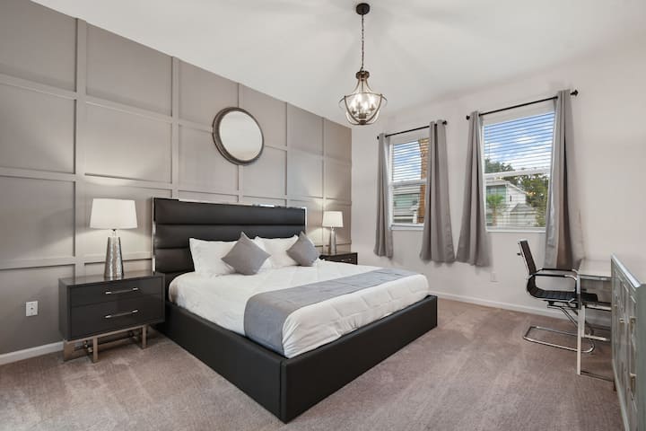 Sofisticado dormitorio principal con una decoración moderna, lujosa ropa de cama y un elegante espacio de trabajo.