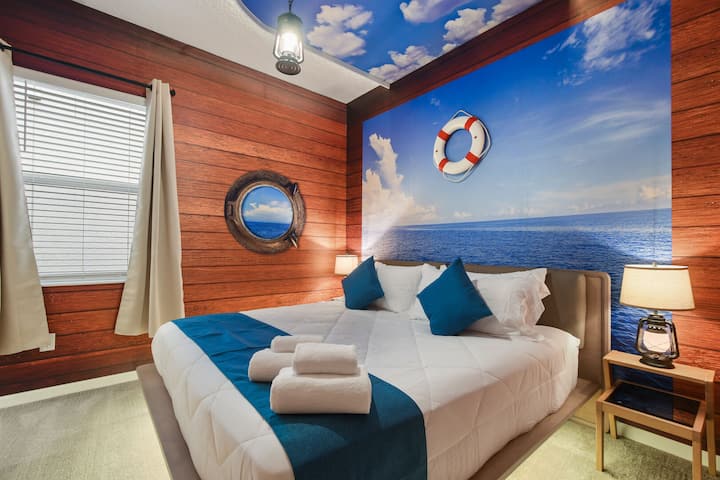 Dormitorio de temática náutica con vistas al mar, detalles de madera y una acogedora decoración marítima.