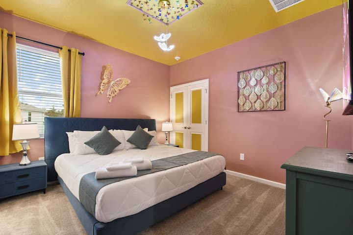 Dormitorio vibrante inspirado en la naturaleza con detalles de mariposa, colores llamativos y una decoración acogedora.